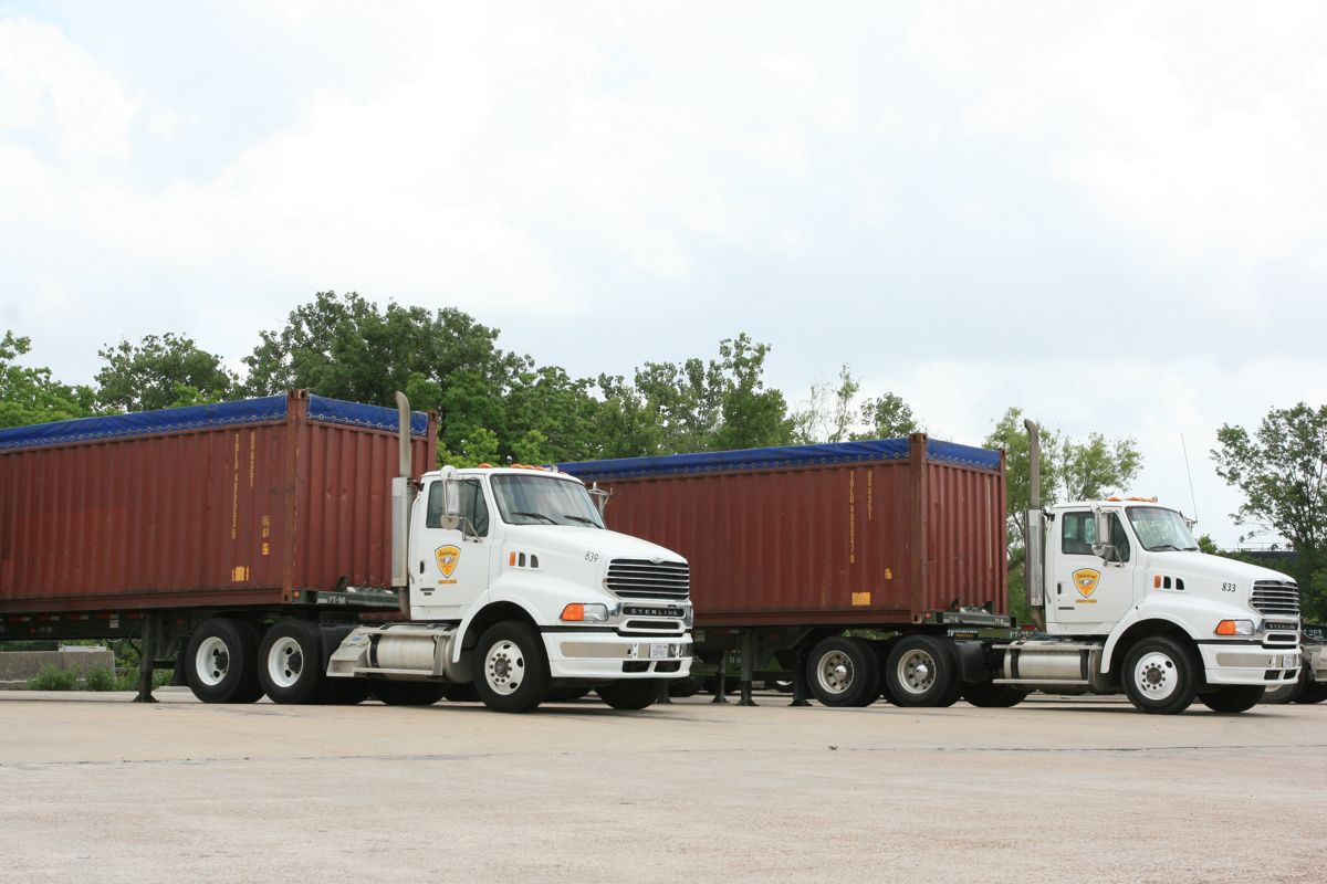 Semi trucks hauling shipping containers on chassis